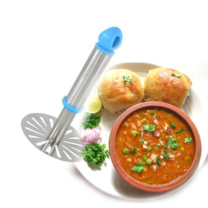 Potato masher with plastic handle next to a bowl of curry and bread rolls on a plate