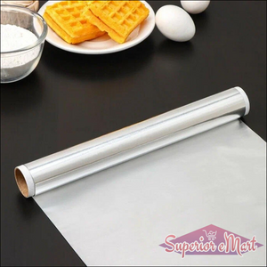 Heavy duty aluminum foil roll on a kitchen counter with cooking ingredients and waffles