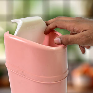 Pink mini trash can with lid being used for kitchen waste management