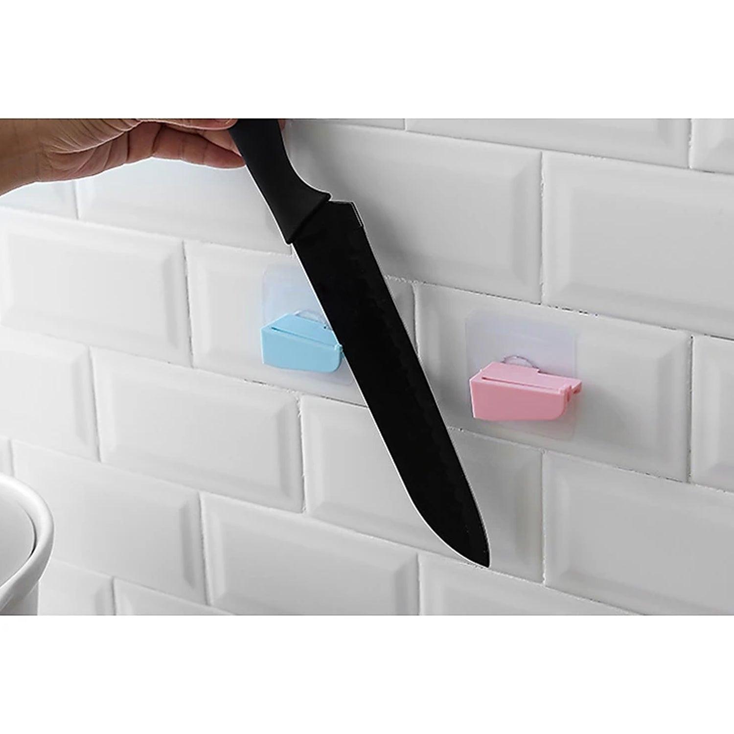 Punch free knife holder mounted on a wall with a hand placing a knife in it
