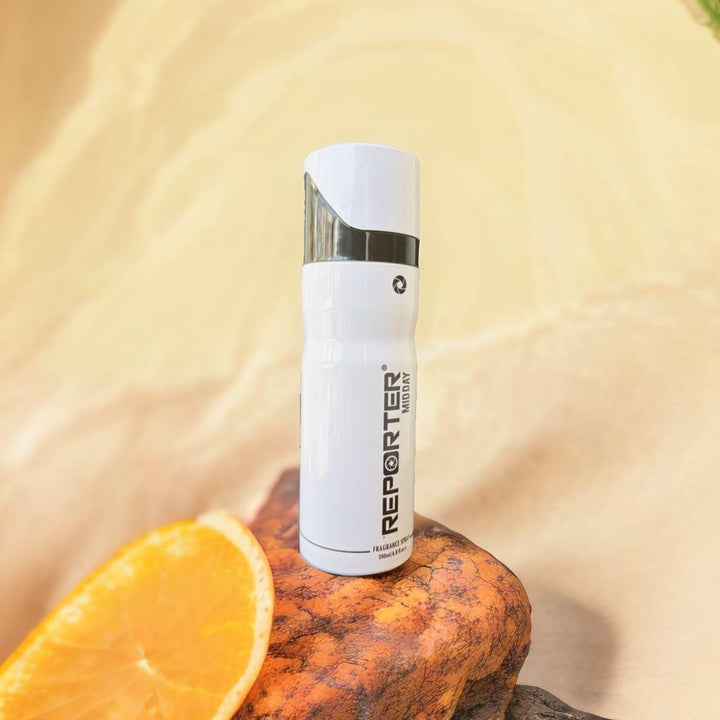 Reporter Midday Fragrance Spray 200ml on a wooden surface next to a fresh orange slice