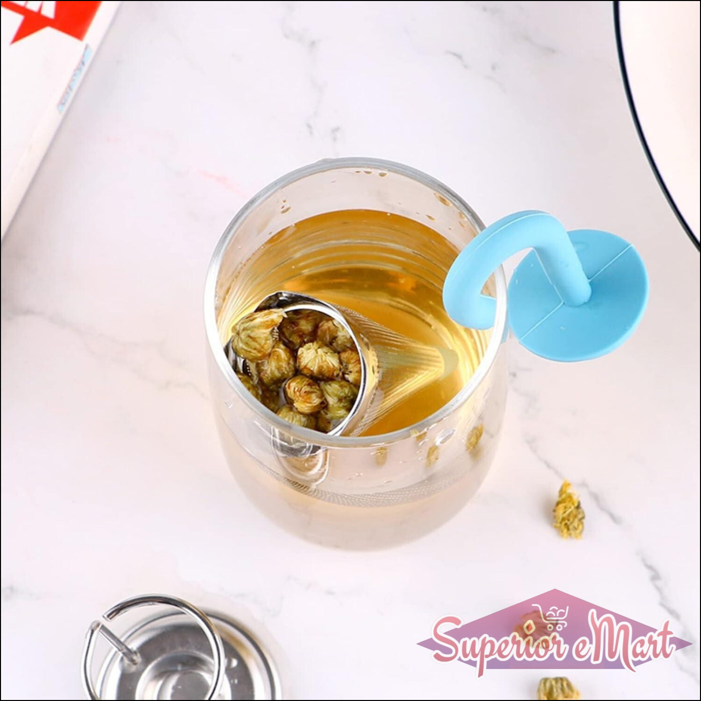 Cute umbrella tea strainer in blue, steeping flowers in a clear glass cup of tea