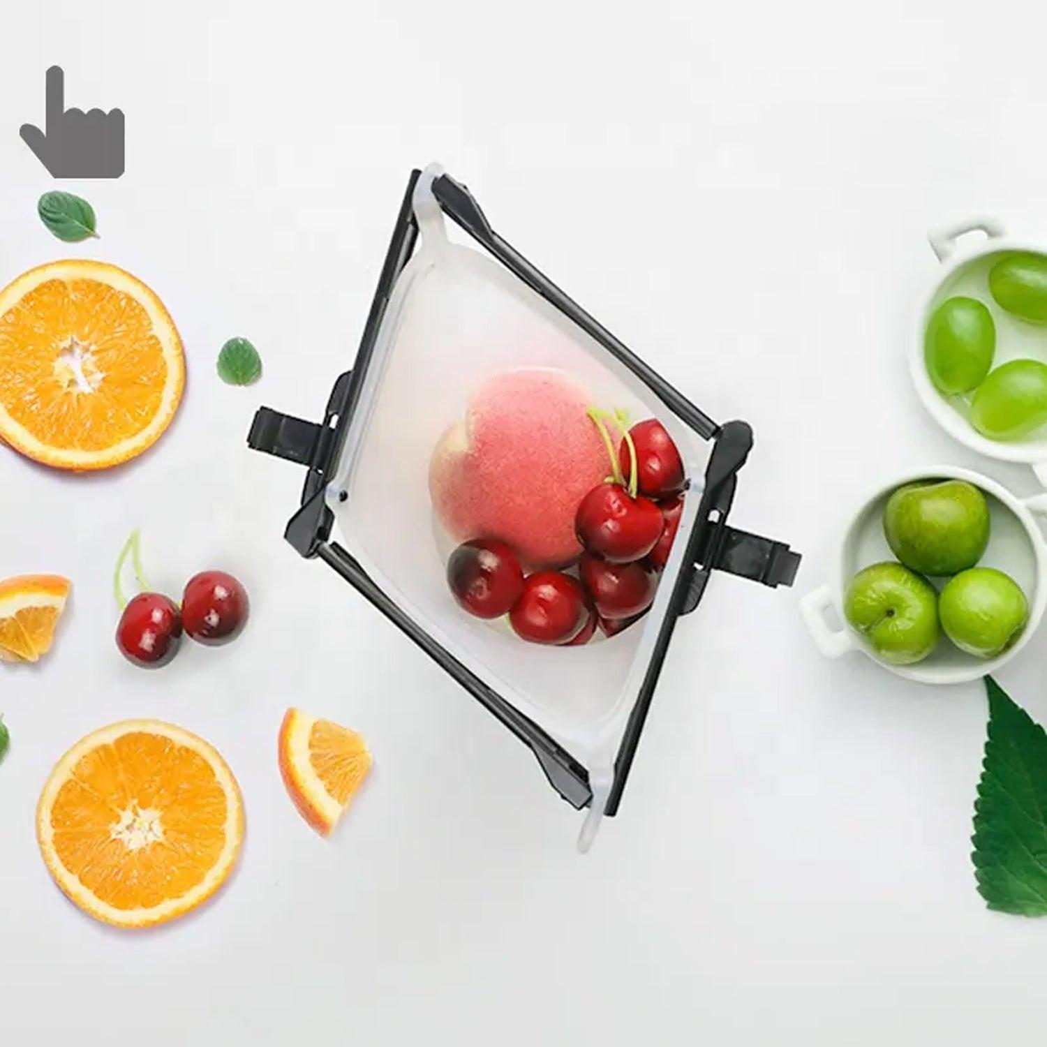 Reusable silicone food storage bag with fresh fruits including cherries and oranges on a white background