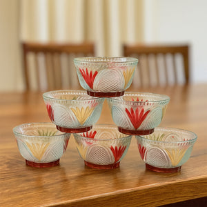 Rose glass dessert bowl set stacked on a wooden table, featuring colorful floral designs