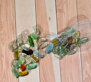 Colorful round marbles for aquarium in various hues scattered on a wood surface