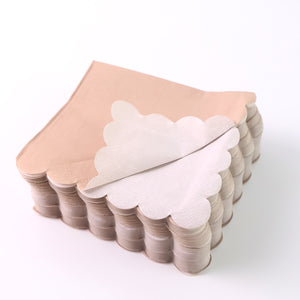 Scalloped edge disposable napkins in beige and white stack for elegant table settings