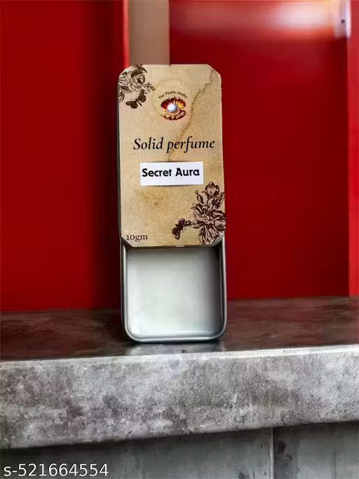 Secret Aura solid perfume in a metal tin with floral design for a unique fragrance experience