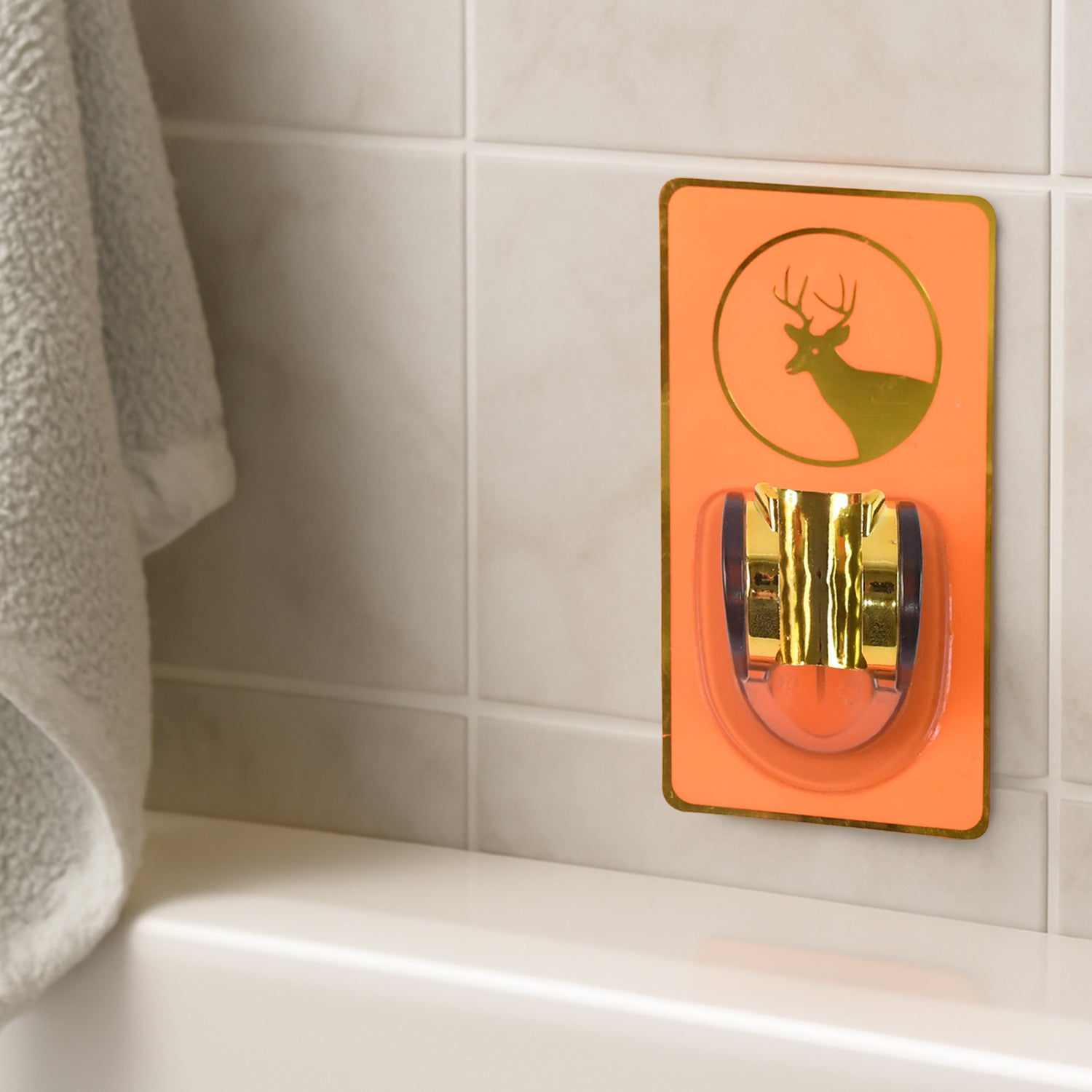 Self-adhesive shower head holder in orange and gold design for easy shower organization