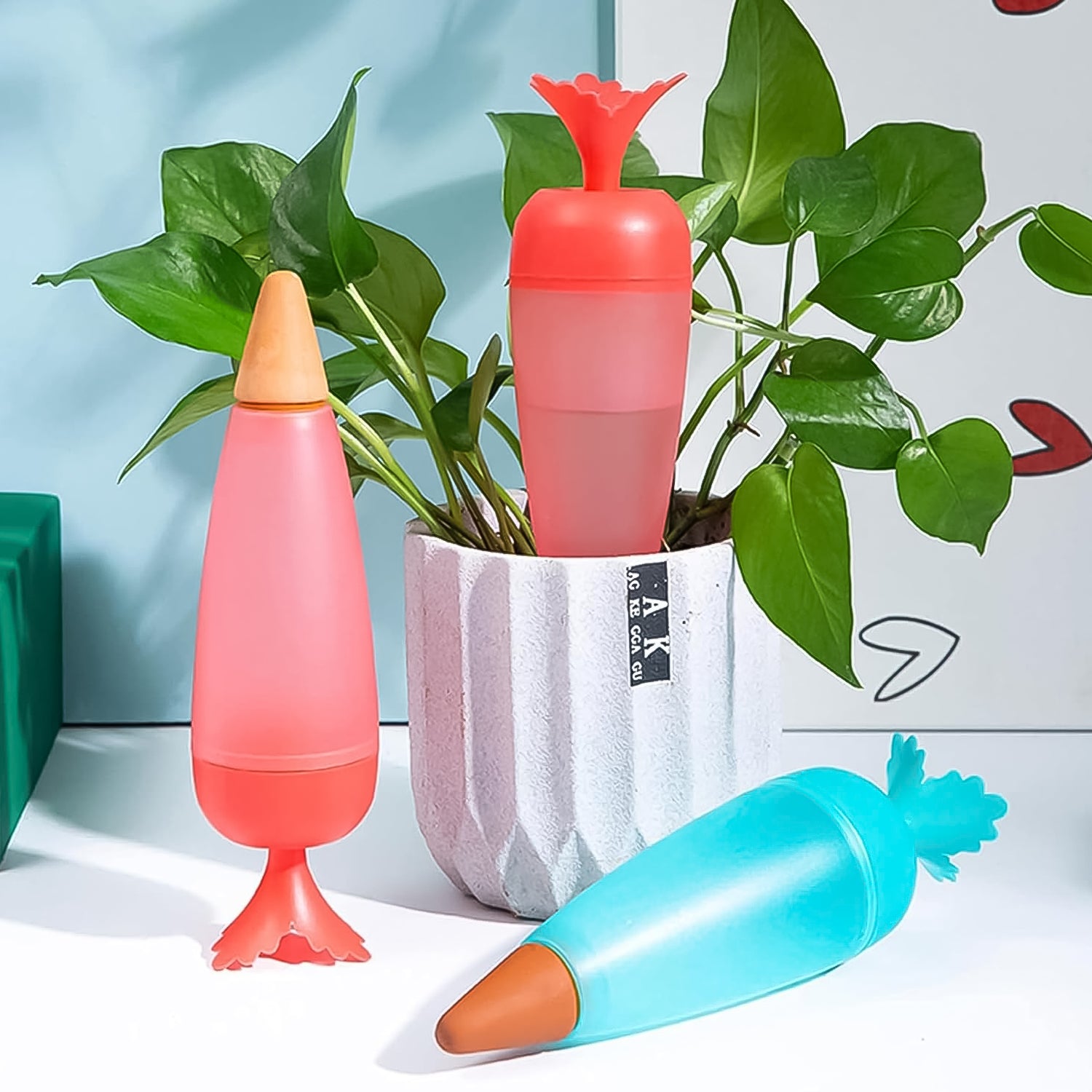 Colorful self watering plant spikes 1 Pc for easy plant hydration, placed next to a potted plant