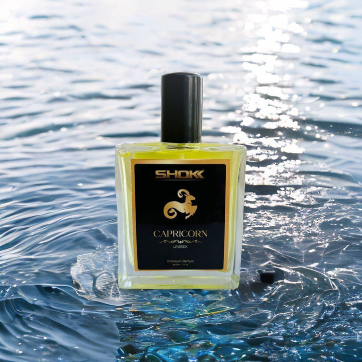 Capricorn Zodiac Unisex Perfume 50ml in a clear bottle against a reflective water background