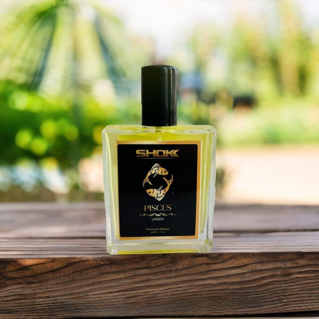 Pisces zodiac unisex perfume 50ml bottle on a wooden table with a blurred garden backdrop