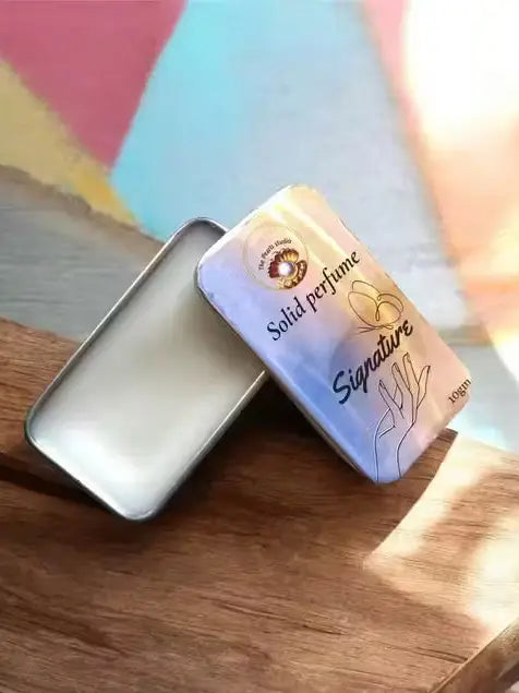 Solid perfume packaging with 'Signature' branding on a wooden surface