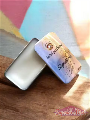 Solid perfume packaging with 'Signature' branding on a wooden surface
