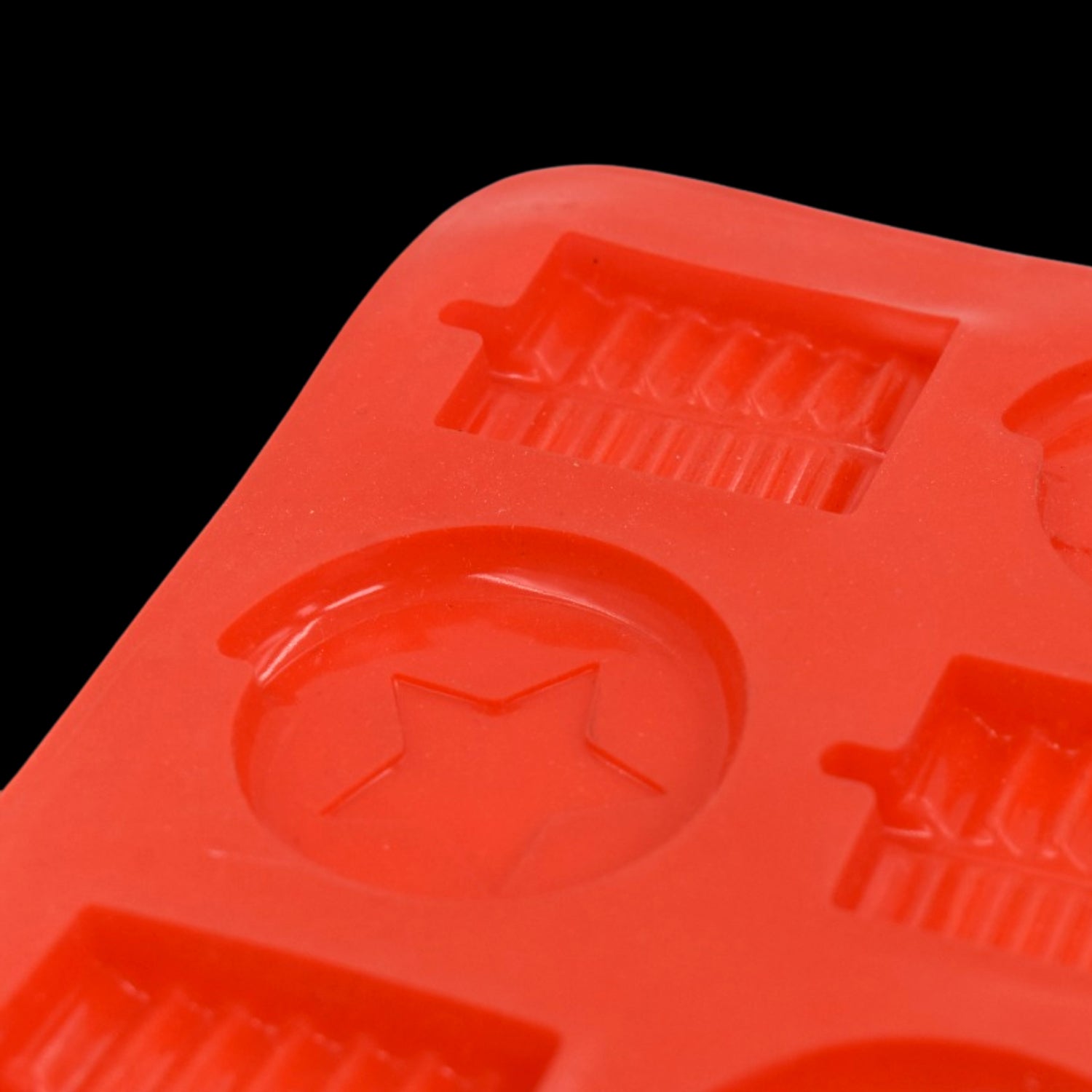 Red silicone chocolate mold tray with various shapes for creating fun chocolate treats