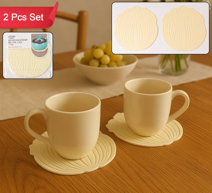 Set of 2 silicone leaf coasters in cream color for protecting tabletops from heat and moisture