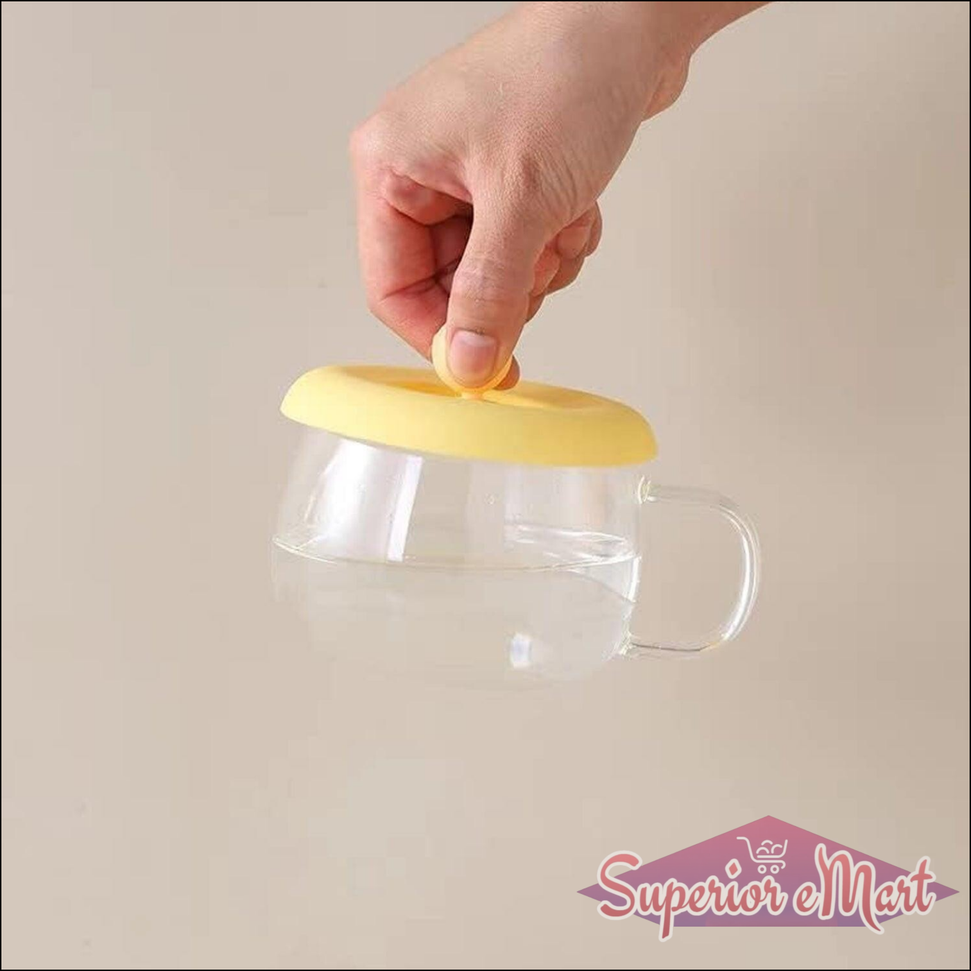 Silicone mug lid airtight seal in yellow being placed on a glass mug to preserve beverage freshness