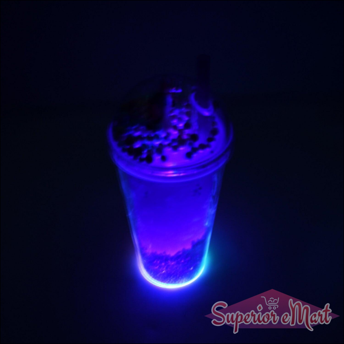LED glow sipper bottle for kids illuminating with vibrant blue light in a dark setting