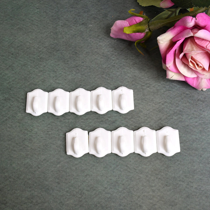Small adhesive hooks in white, ideal for organizing home and kitchen spaces