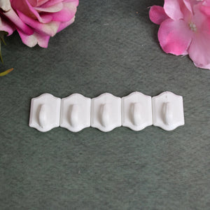 Set of small adhesive hooks in white for hanging and organizing home items