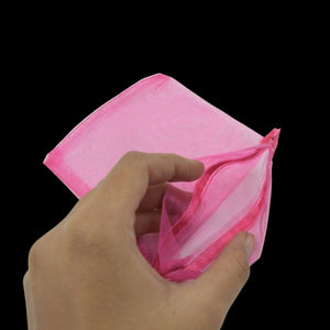 Hand holding a pink small organza gift bag with drawstring for elegant gift wrapping
