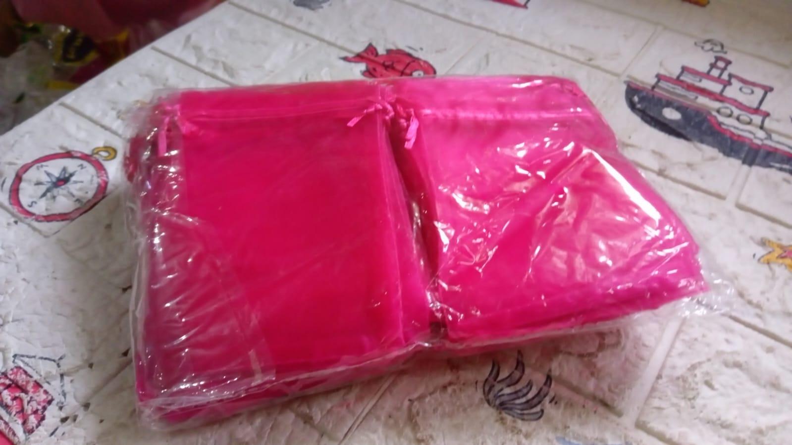 Pack of small organza gift bags in vibrant pink color, ideal for party favors and special occasions
