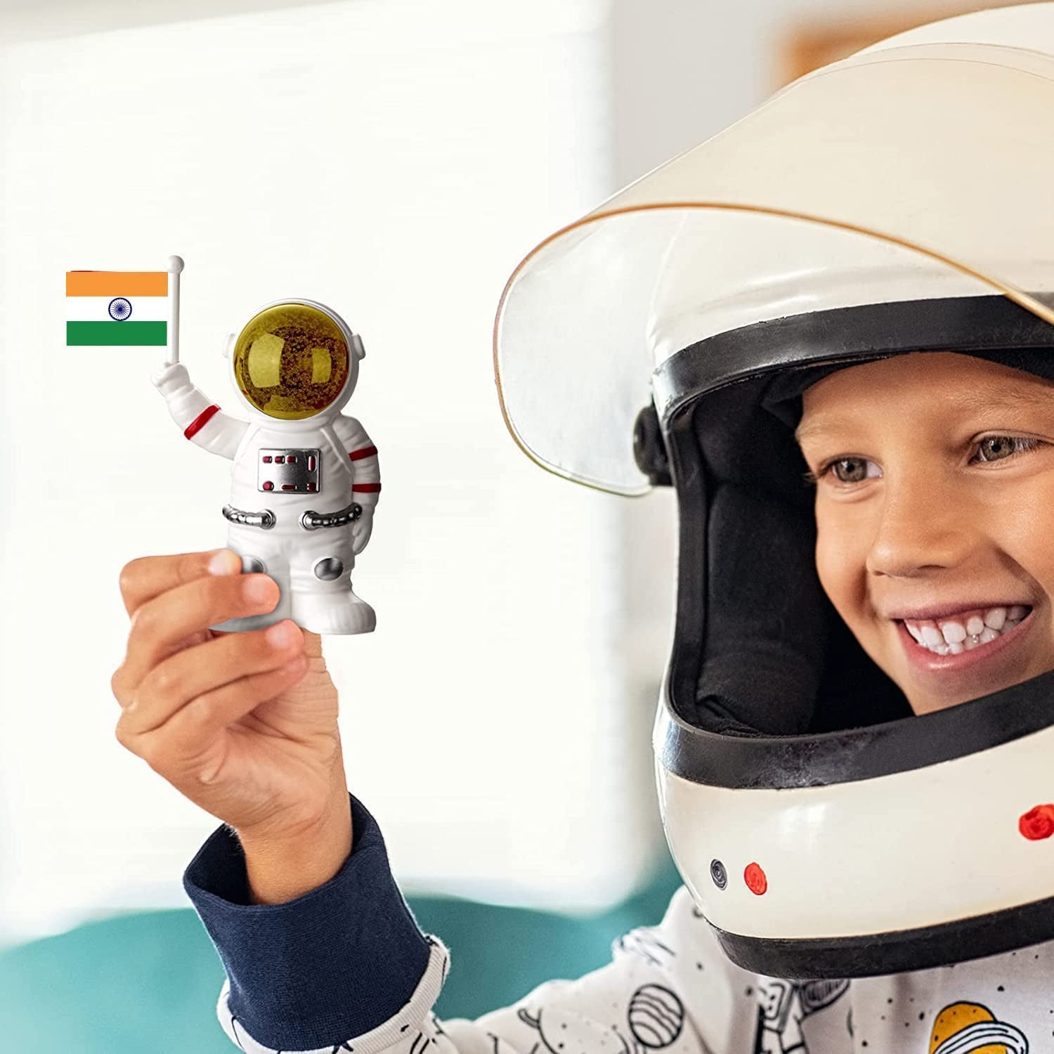 Child holding a solar power astronaut ornament while wearing a space helmet for fun decor