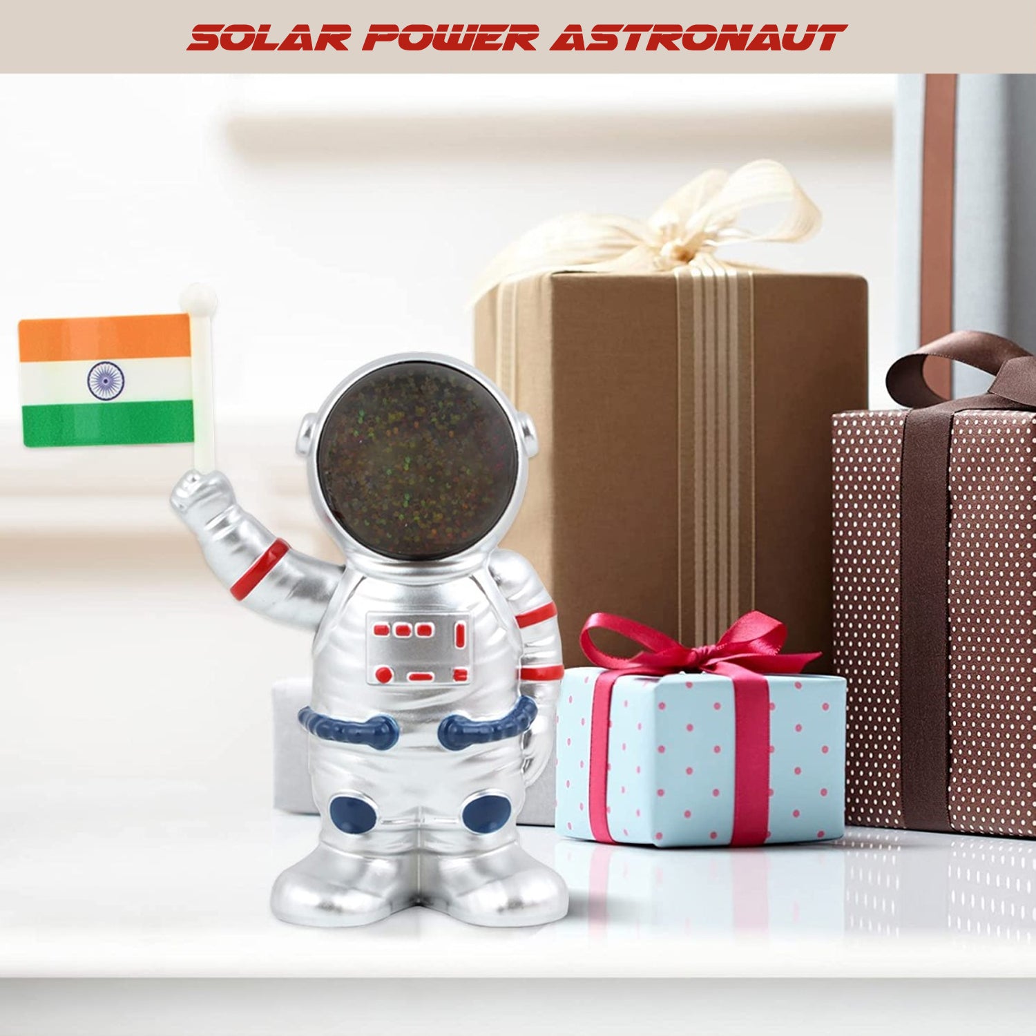 Solar power astronaut ornament holding an Indian flag beside colorful gift boxes in home decor setting