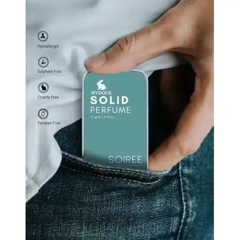 Teal Mydoux Soiree Solid Perfume tin sliding into a denim pocket. Portable, hypoallergenic, and cruelty-free.
