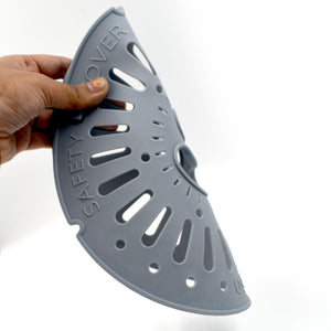Hand holding a gray spin cap safety cover designed for kitchen use and food protection