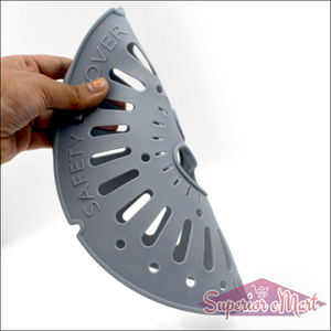 Hand holding a gray spin cap safety cover designed for kitchen use and food protection