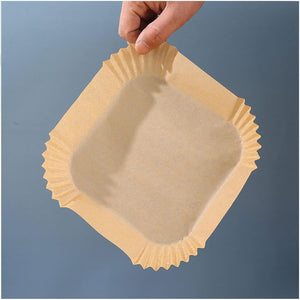 Hand holding a square air fryer liner disposable showcasing grease-resistant parchment material