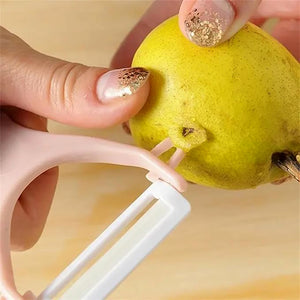 Superior eMart stainless steel blade vegetable peeler in use peeling a pear for kitchen tasks