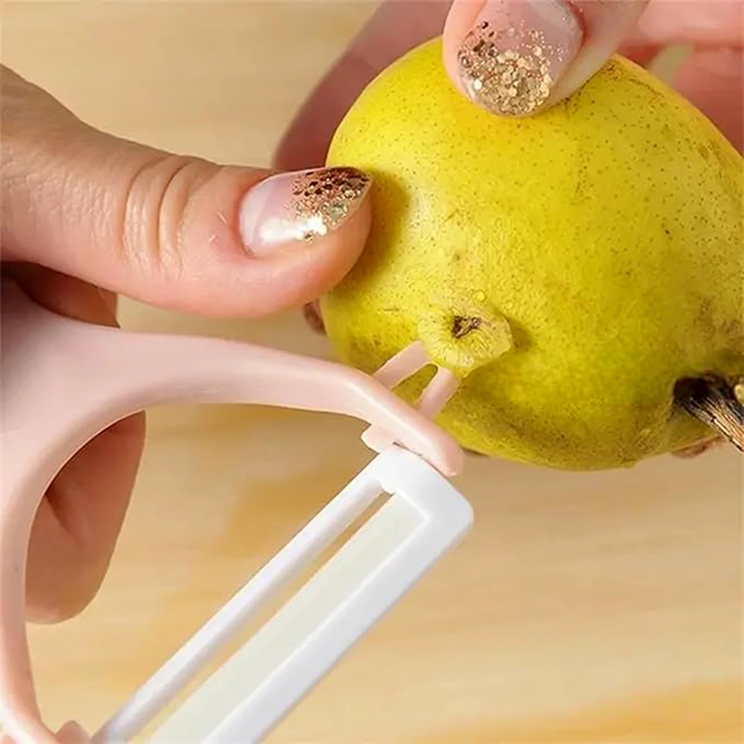 Superior eMart stainless steel blade vegetable peeler in use peeling a pear for kitchen tasks