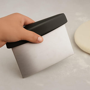 Stainless steel dough scraper with a black ergonomic handle for easy lifting and cutting dough