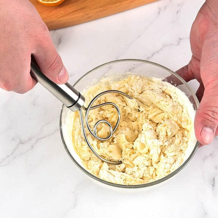 Superior eMart stainless steel dough whisk mixing batter in a glass bowl on a marble countertop