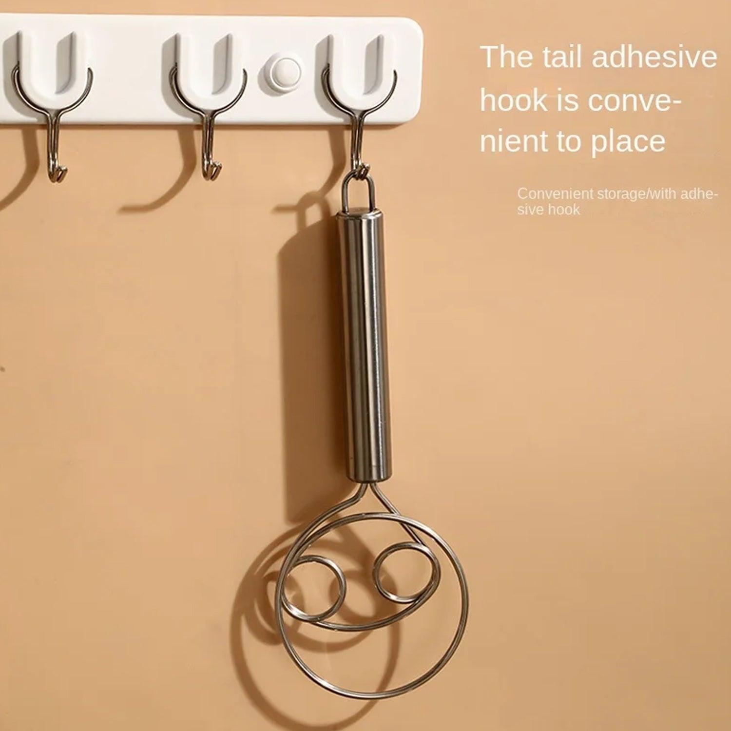 Stainless steel dough whisk hanging on hooks for convenient kitchen storage