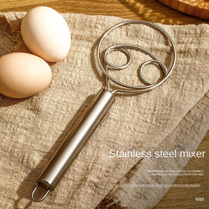 Superior eMart stainless steel dough whisk with a comfortable handle and eggs on a textured cloth