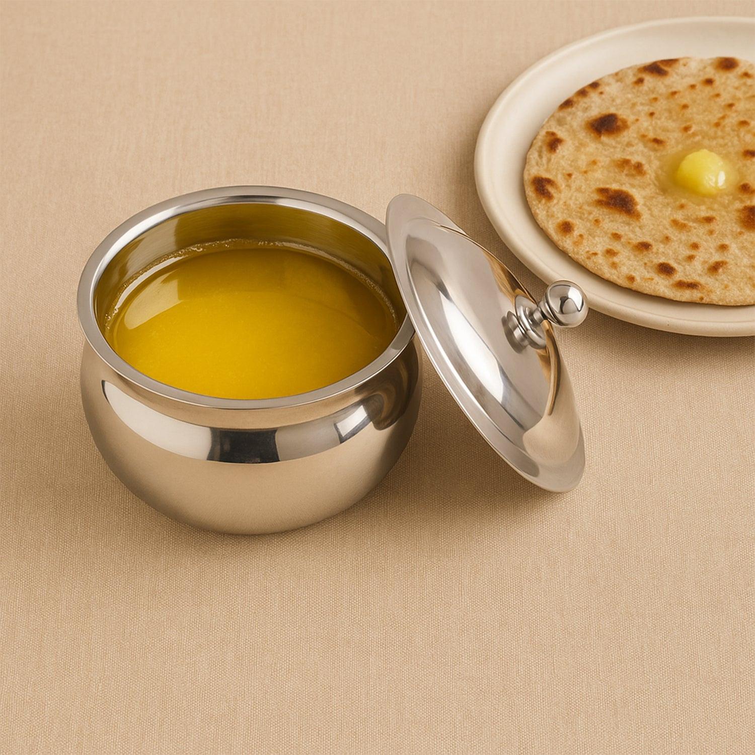 Superior eMart stainless steel ghee pot with lid alongside a traditional Indian flatbread