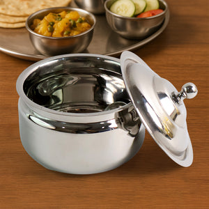 Superior eMart stainless steel ghee pot with lid open on wooden table near Indian meal