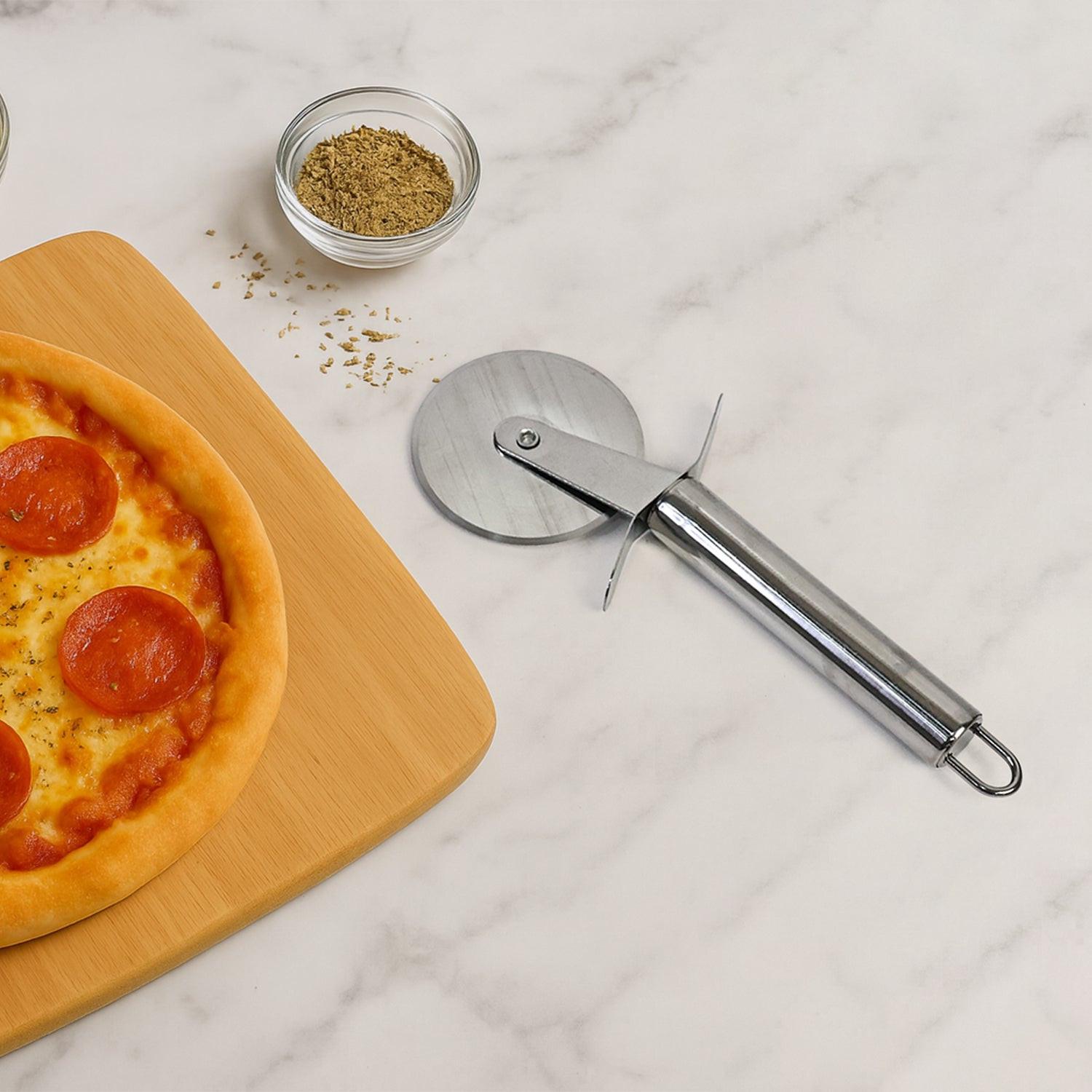 Stainless steel pizza cutter resting beside a freshly baked pepperoni pizza on a cutting board
