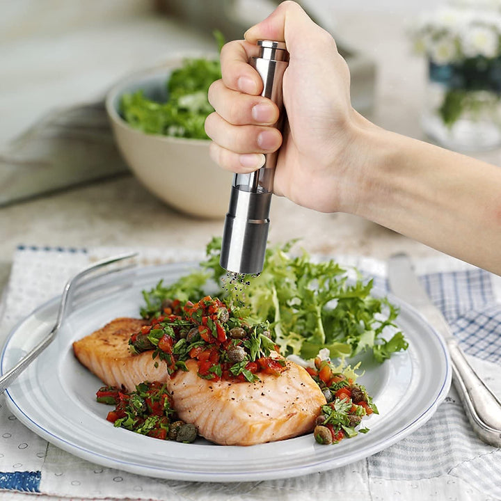 Stainless Steel Salt And Pepper Grinder 1 Pc being used to season grilled salmon with fresh herbs and greens