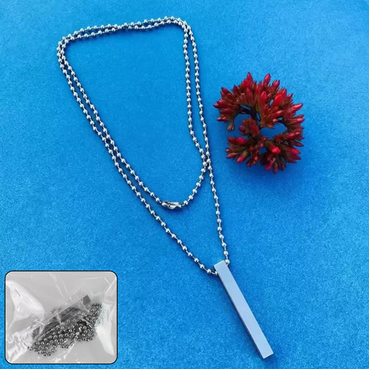 Stainless steel stick necklace with a sleek design hanging on a blue surface beside a red flower