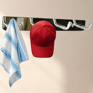 Stainless steel wall mounted coat rack with hooks holding a red hat and a striped towel