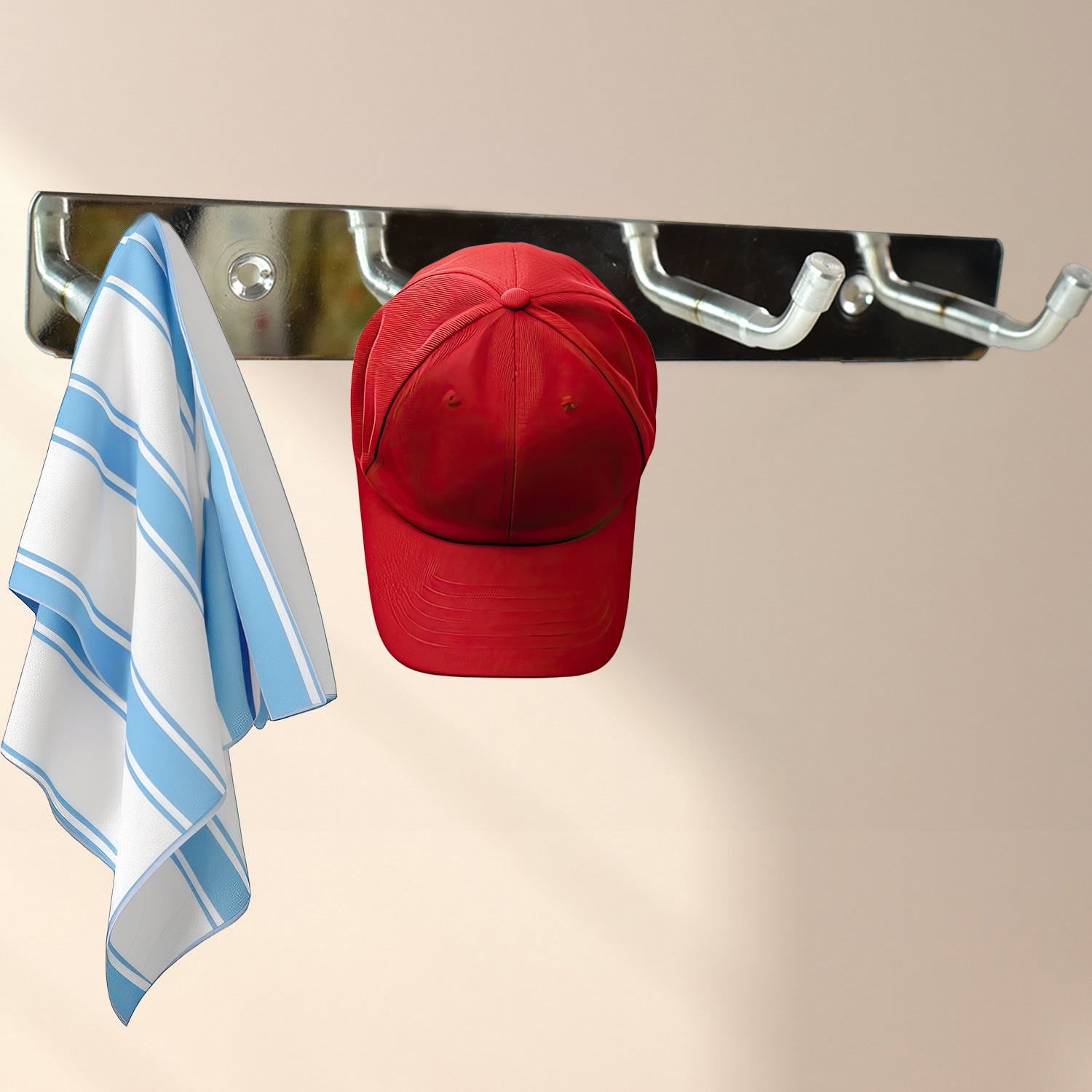 Stainless steel wall mounted coat rack with hooks holding a red hat and a striped towel