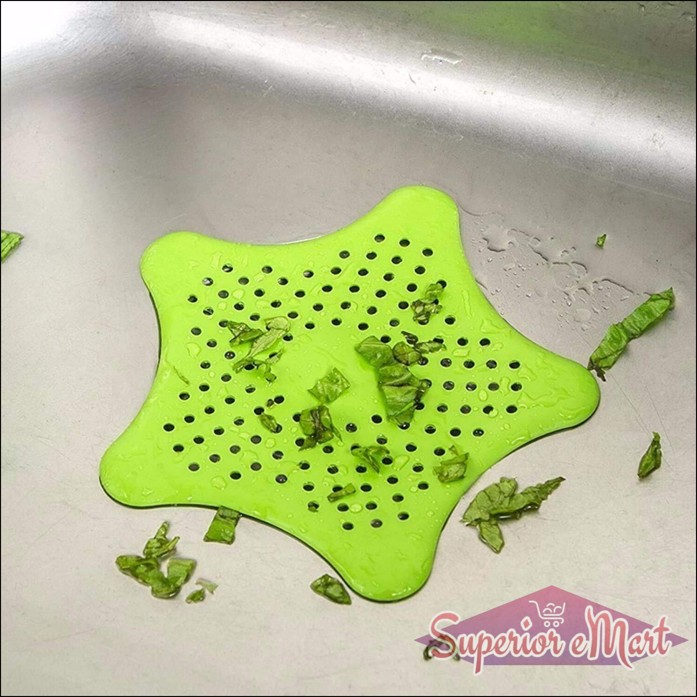 Green star shape sink strainer with drainage holes collecting food scraps in a kitchen sink