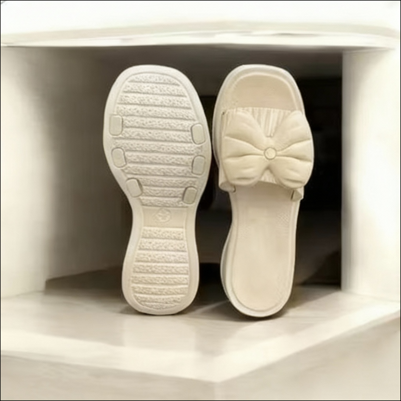 Cream platform slides featuring a puffy bow detail and a textured non-slip sole.