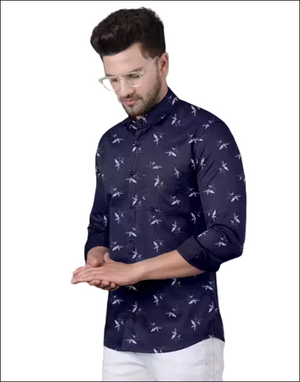 Man wearing a navy blue long-sleeved button-down shirt with a white floral print and white trousers.
