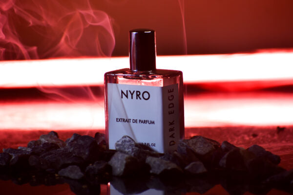 Nyro Dark Edge Extrait de Parfum Bottle on a Stone Surface with Smoke Background