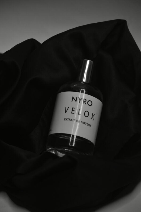 Nyro Velox Extrait de Parfum in a sleek bottle placed on black fabric