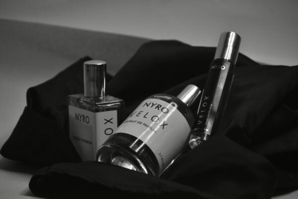 Nyro Velox Perfume Set Featuring Three Bottles of Fragrance on Black Fabric